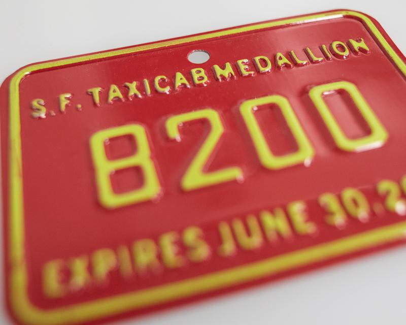 detail view of red and yellow colored taxi medallion plate