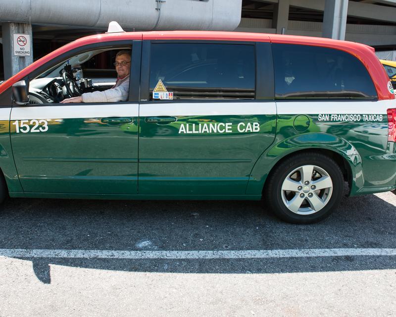 side view of accessible taxi van in green, white and red livery of Alliance Cab