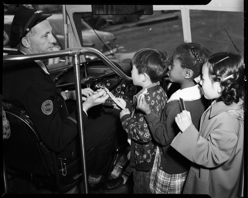 Bus driver greets children in historic photo
