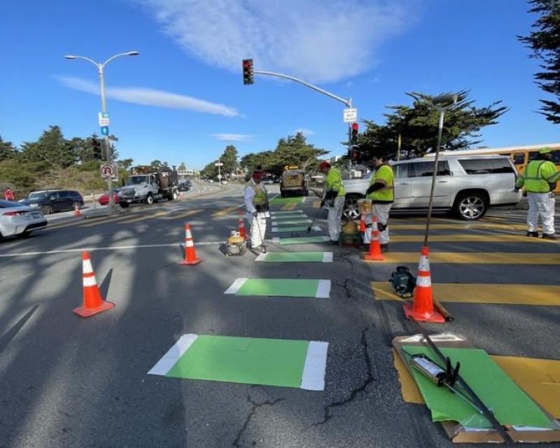SFMTA paint crew installing bike lane green thermo plastic at a crosswalk on lake merced boulevard
