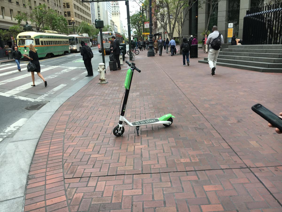 Lime scooter parked on the sidewalk on Market Street