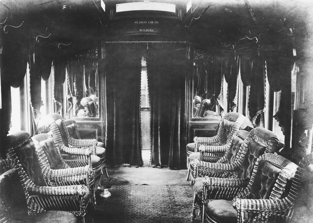wicker chairs inside wood paneled compartment with heavy drapes