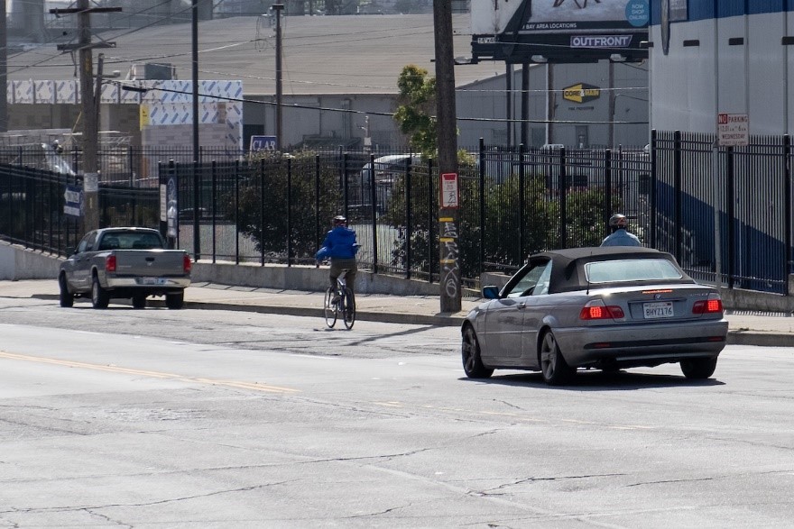 A person bicycling eastbound on Evans Avenue