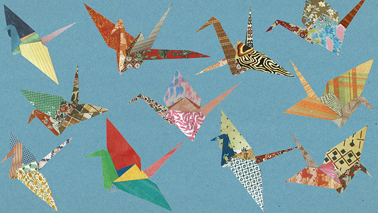 Eleven origami cranes, each bearing multiple patterns in different colors over light blue background