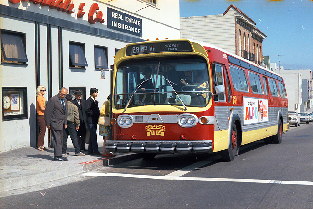 People boarding Muni bus painted red and yellow on 19th avenue.