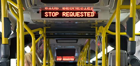 Stantions and straps on a New Flyer bus. Stop Requested is displayed.