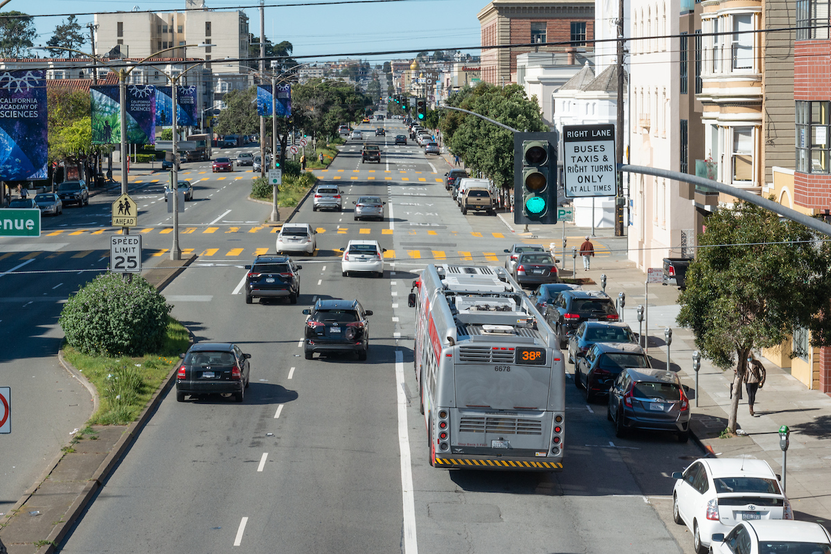 Aerial view of Geary Boulevard in the Richmond. Cars are moving in their lanes beside a 38R traveling in a designated transit lane.
