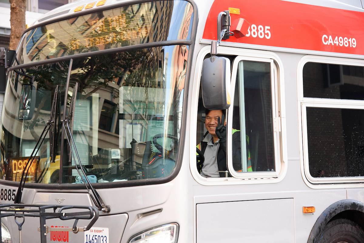 A Muni bus driver waves while on his route.