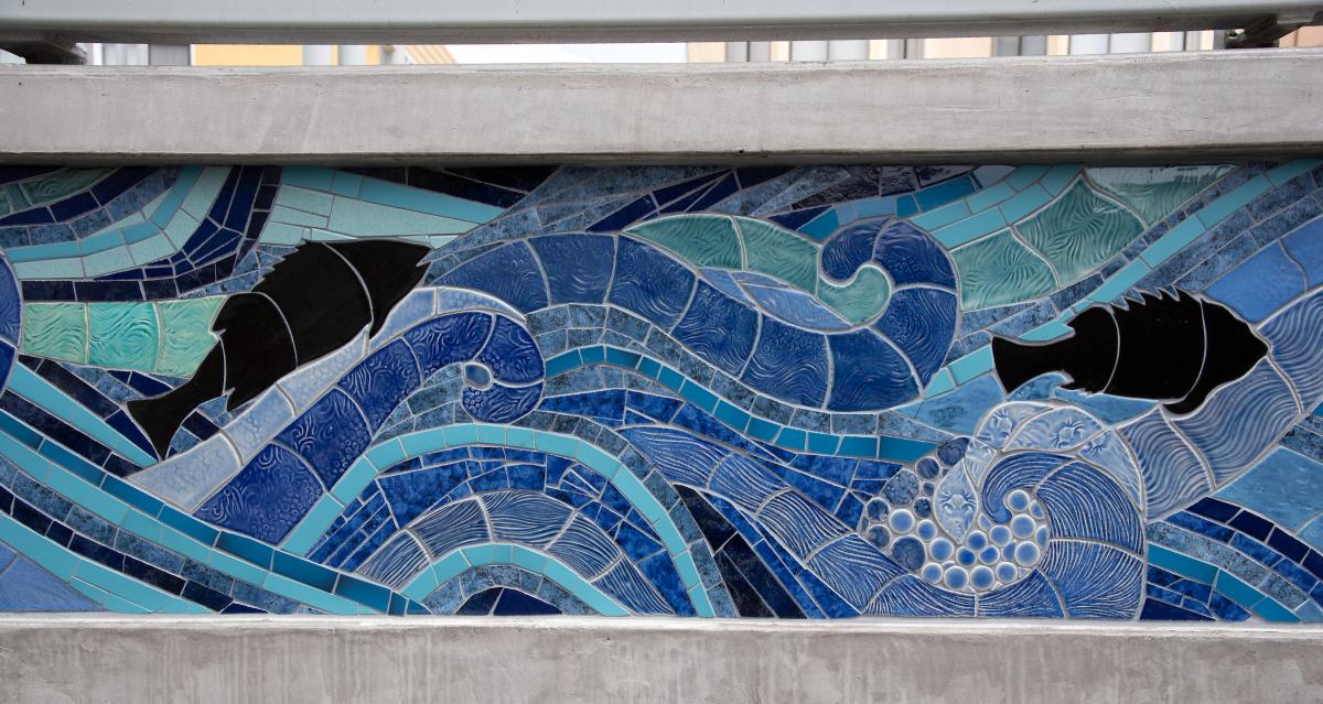 Example of artwork on the new boarding islands along the L Taraval line. Various blue and green tiles portray a water body and waves.