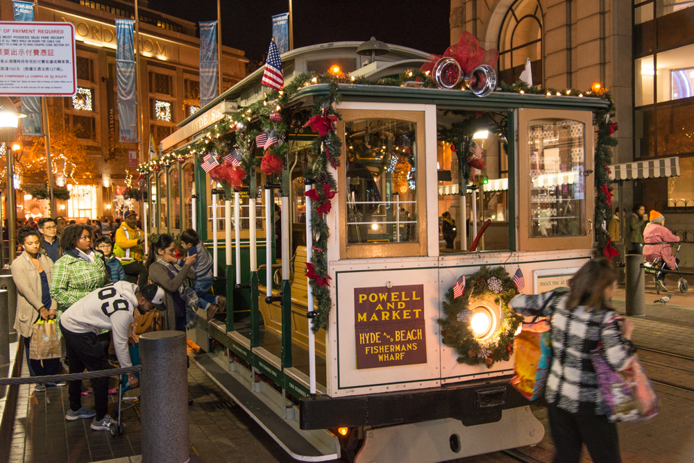 decorated cable car with passengers in 2017.  Link to Blog Post Cable Cars Get Festive for the Holidays.