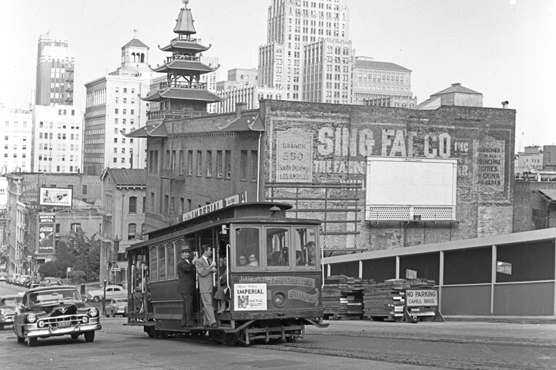 A cable car climbs the hill on California Street in 1951 with Chinatown and downtown skyline visible in the background.