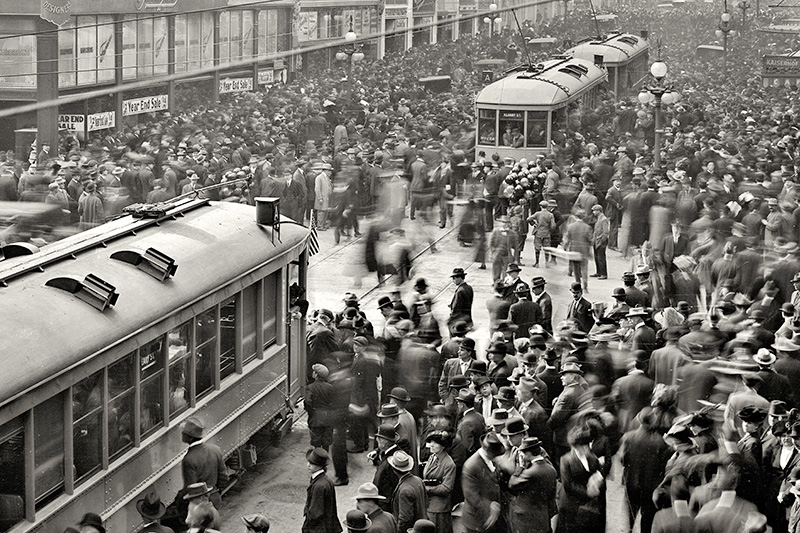 A large crowd gathers around two streetcars on Geary Street at Grant Avenue on December 28, 1912, to celebrate the opening day of the San Francisco Municipal Railway.