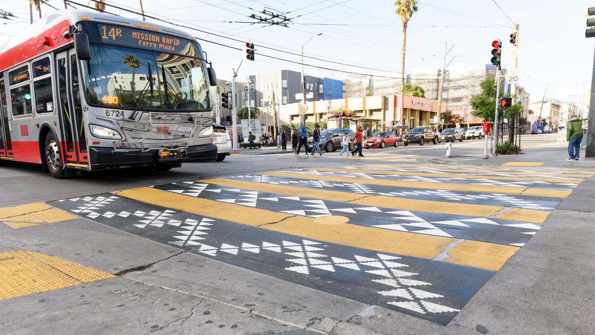 A 14R Mission Rapid approaches the decorative crosswalk at 16th and Mission streets.