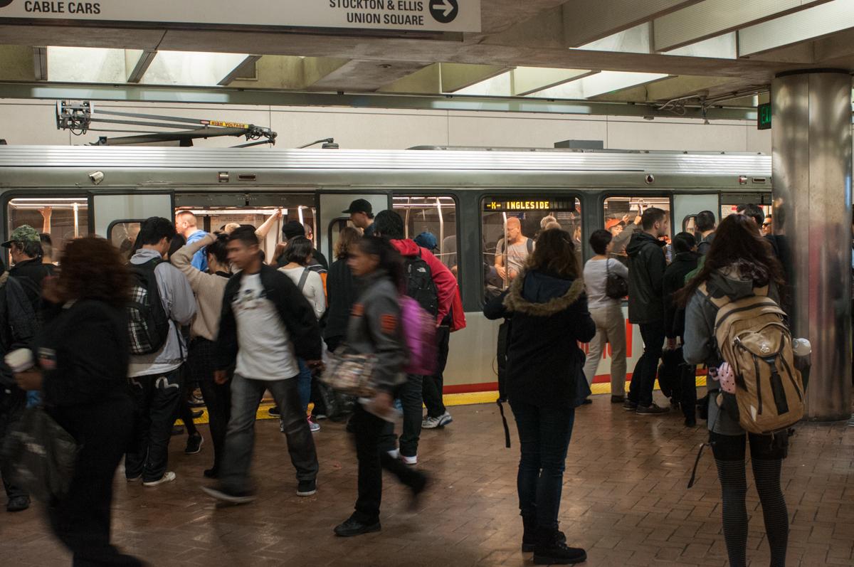 K Ingleside train stops to serve a crowded Powell Station platform.