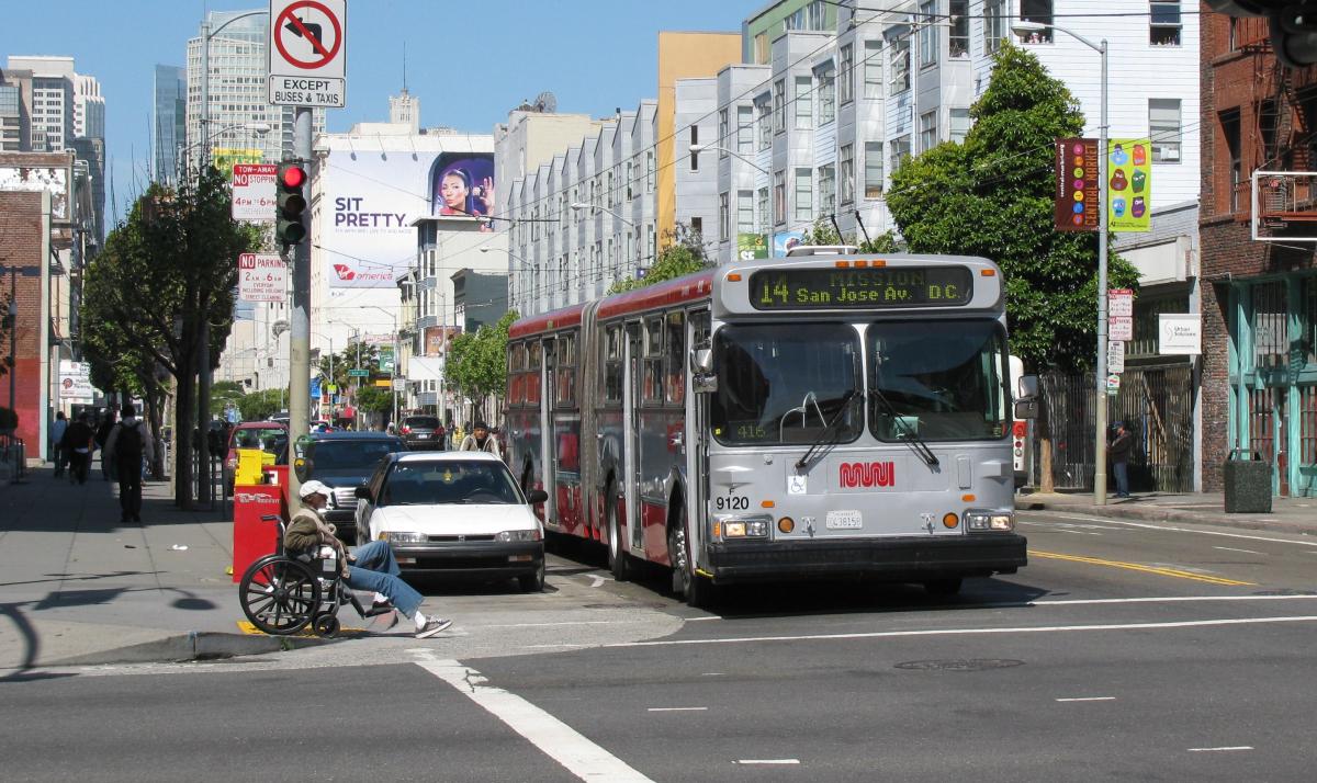 # Alt Text</p>
<p>Muni bus number 14 heading to San Jose stops at a downtown intersection with pedestrians and vehicles nearby.