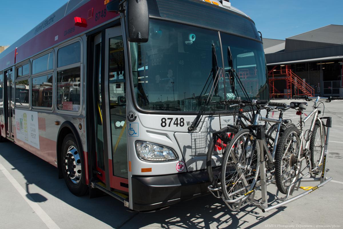Transit bus with high-capacity bike rack holding multiple bicycles on front bumper.