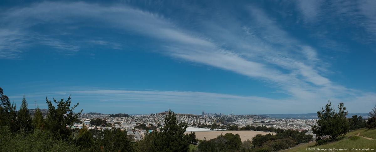 Panoramic view of San Francisco cityscape and surrounding hills from McLaren Park under blue sky