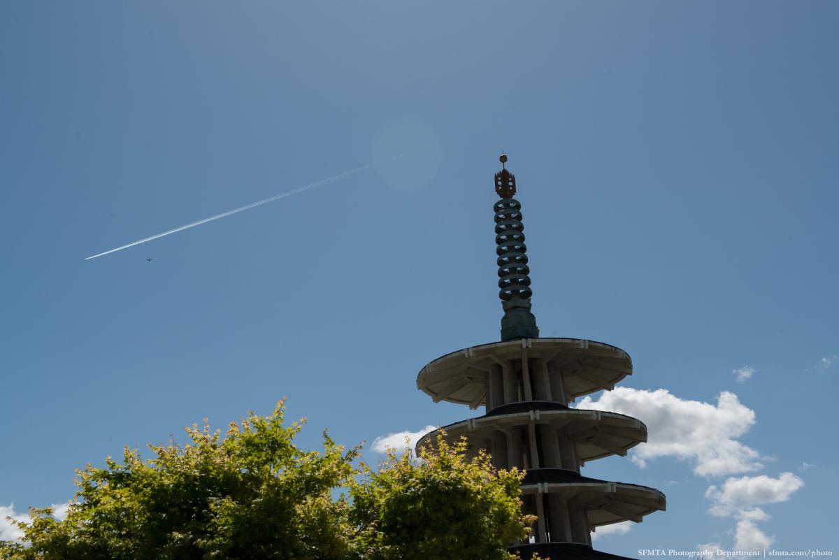 Peace Pagoda in Japantown with blue sky, white clouds, and an aircraft contrail visible above.