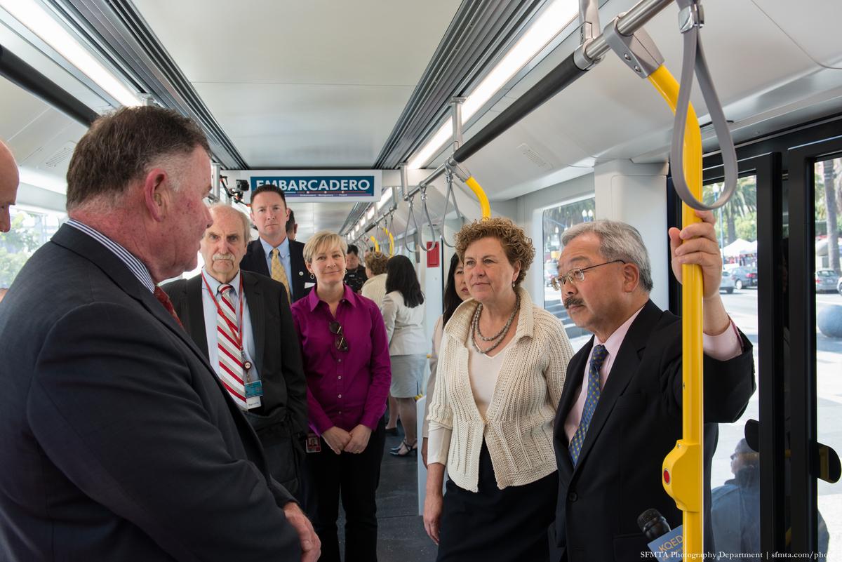 Officials and staff tour the interior of a light rail vehicle mock-up on The Embarcadero.