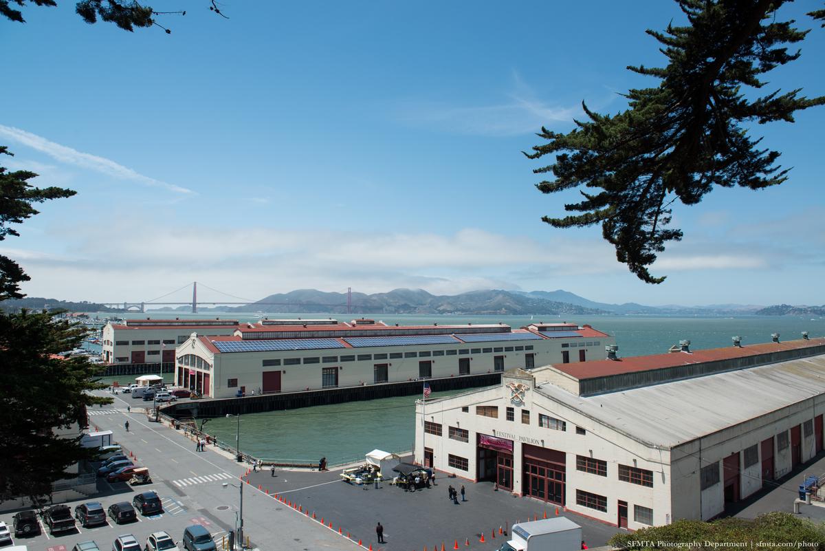 Fort Mason Center waterfront facility with piers, buildings, and San Francisco Bay view including Golden Gate Bridge.