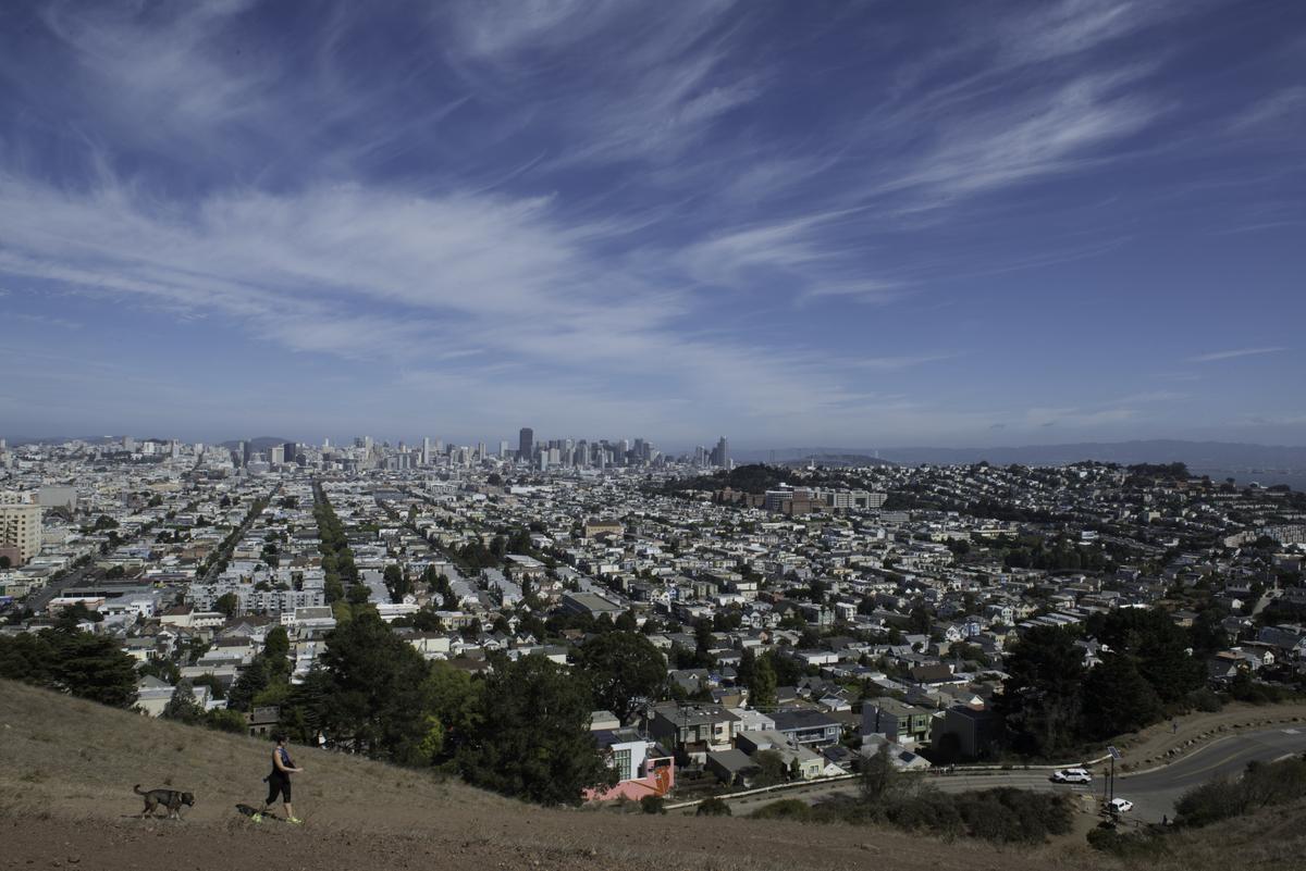 Panoramic view of San Francisco cityscape from Bernal Heights hilltop with downtown skyline and residential neighborhoods visible.