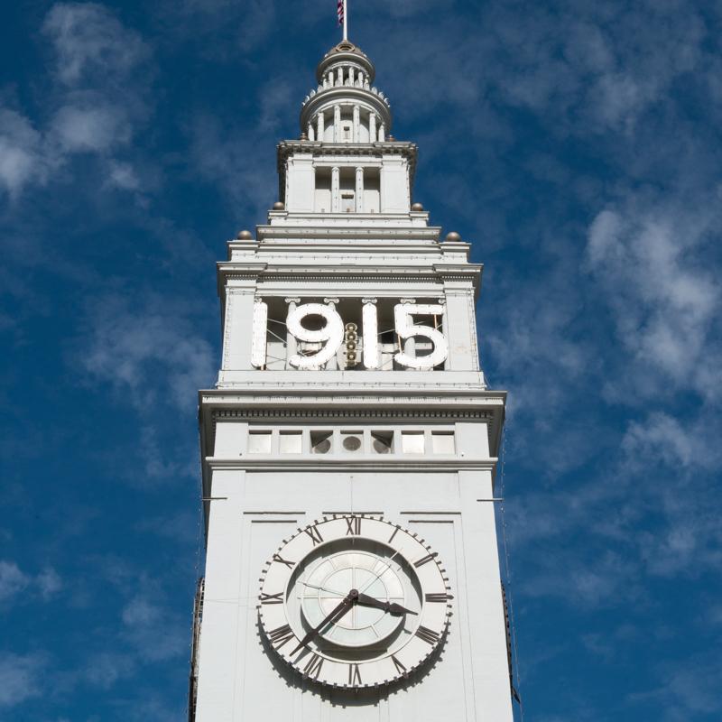 Ferry Building clock tower with 1915 signage against blue sky
