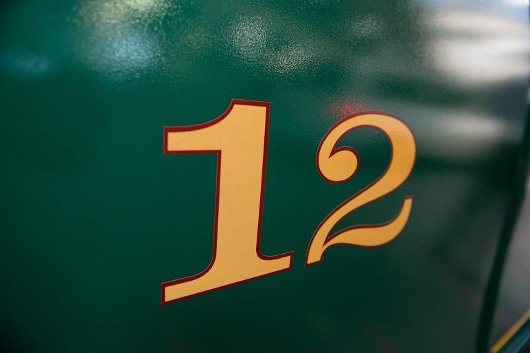 Gold number 12 on green cable car exterior