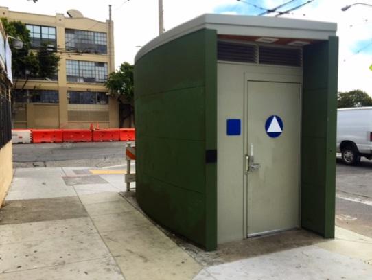 Green and grey rectangular operator convenience station on urban sidewalk