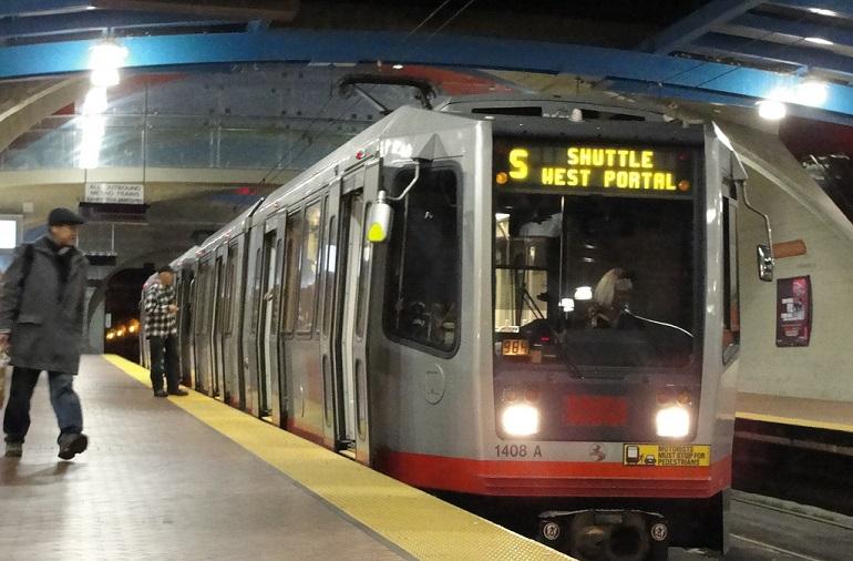 Muni Metro train at West Portal station with S Shuttle West Portal headsign displayed.