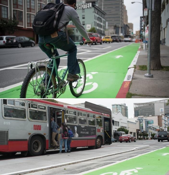 Cyclist riding on green-painted bike lane; bus stopped at boarding island on street below.