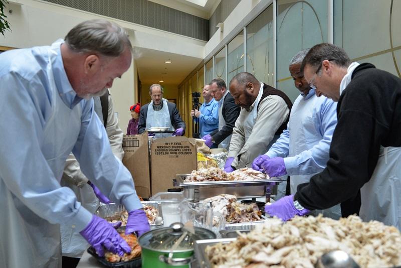 SFMTA and TWU Local 250-A leaders prepare and serve food at holiday luncheon event.