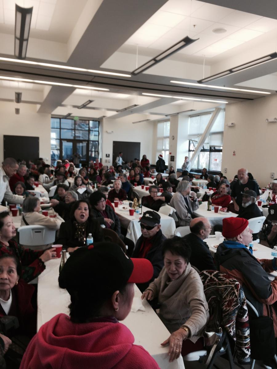 Seniors seated at tables in a bright banquet room during a holiday lunch event