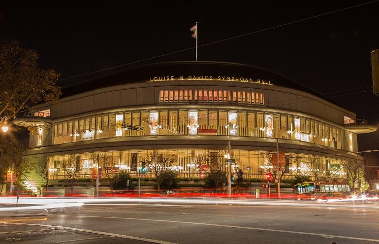Louise M Davies Symphony Hall illuminated at night with light trails from passing traffic.