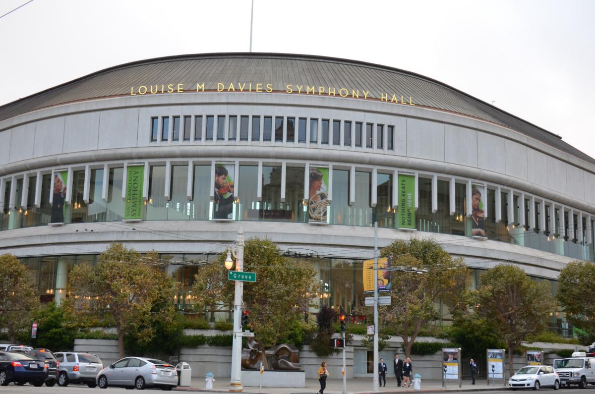 Louise M Davies Symphony Hall exterior with curved architecture, large windows, and street-level entrance with landscaping.