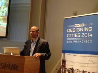 Man speaking at podium during NACTO Designing Cities 2014 conference in San Francisco