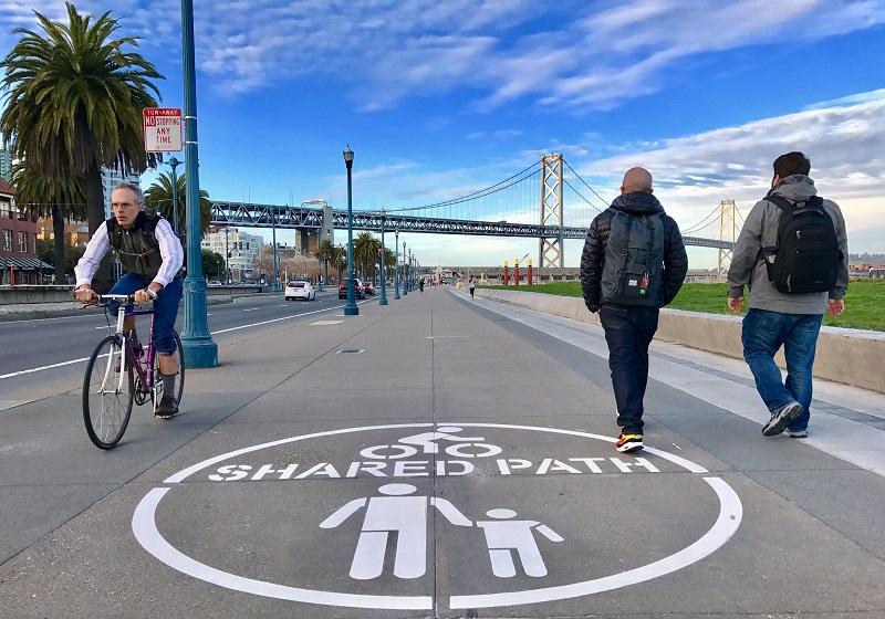 Shared path marking with cyclists and pedestrians near Bay Bridge on the Embarcadero Promenade in San Francisco.