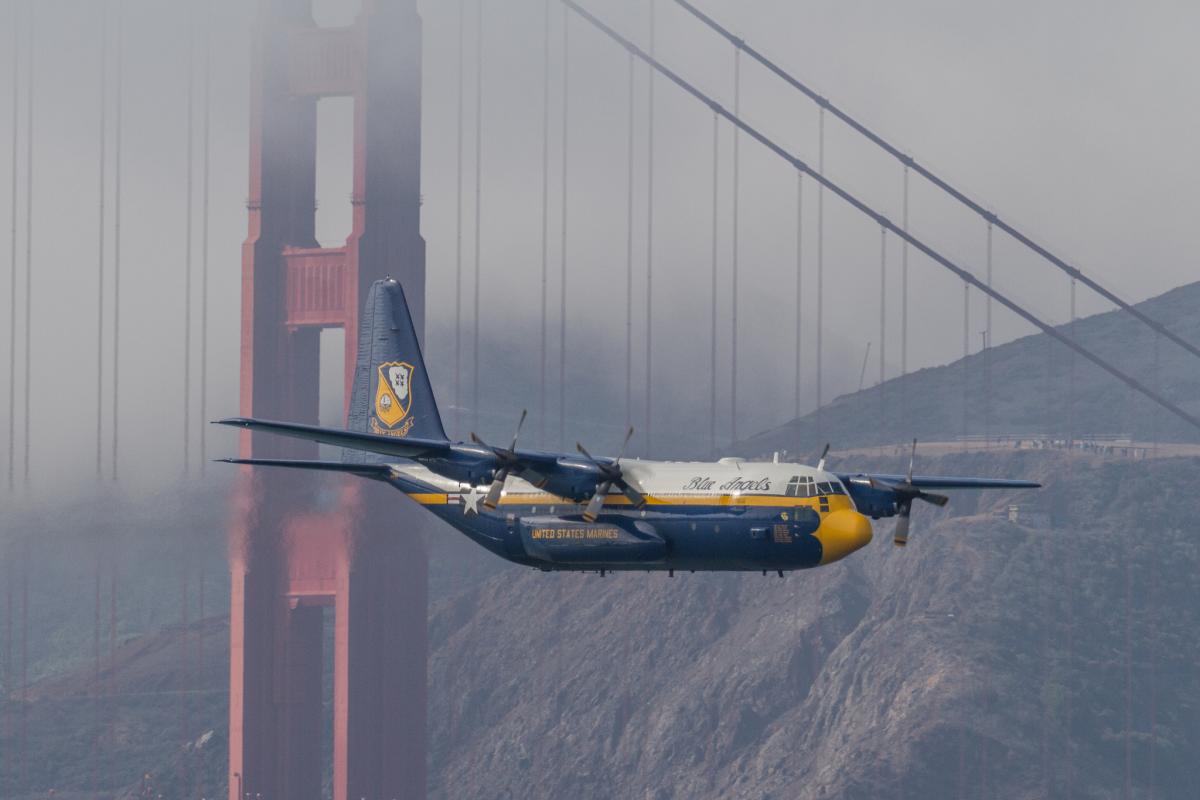 Blue Angels C-130 Hercules transport plane flying past the Golden Gate Bridge in fog