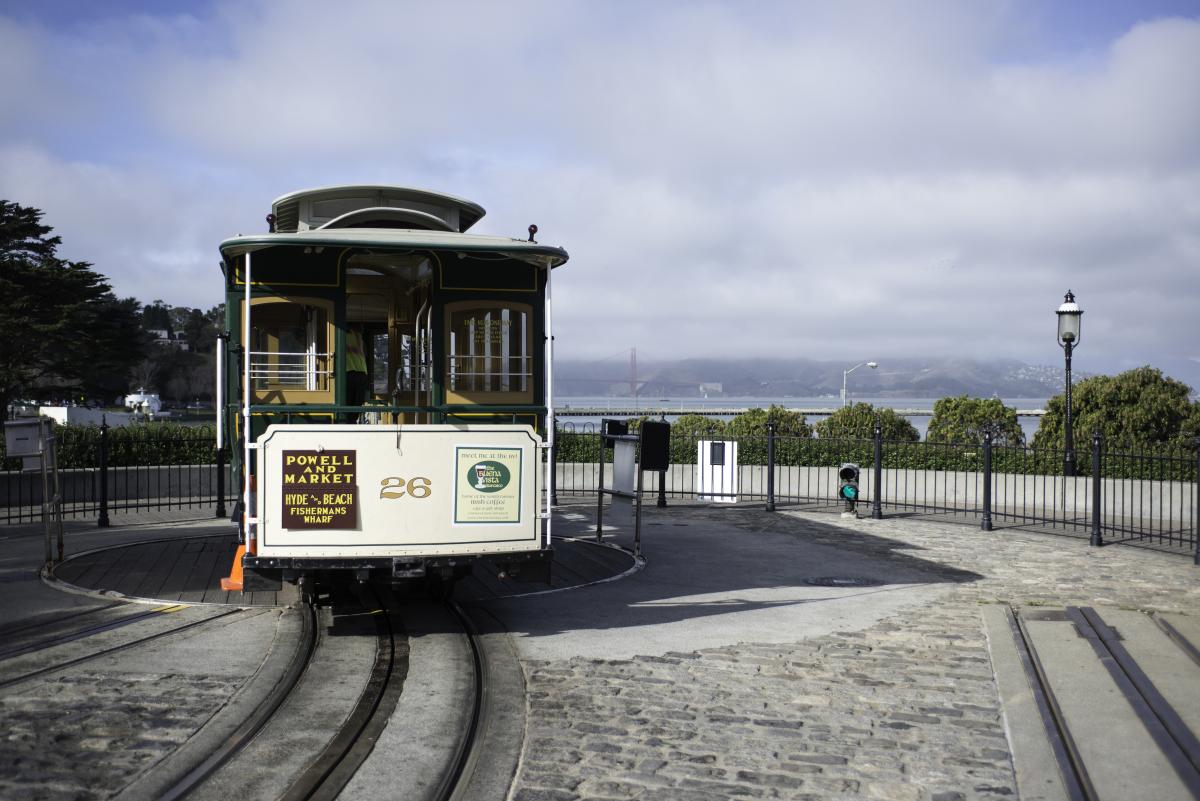 Powell-Hyde Street cable car number 28 on the turntable with bay view in background.