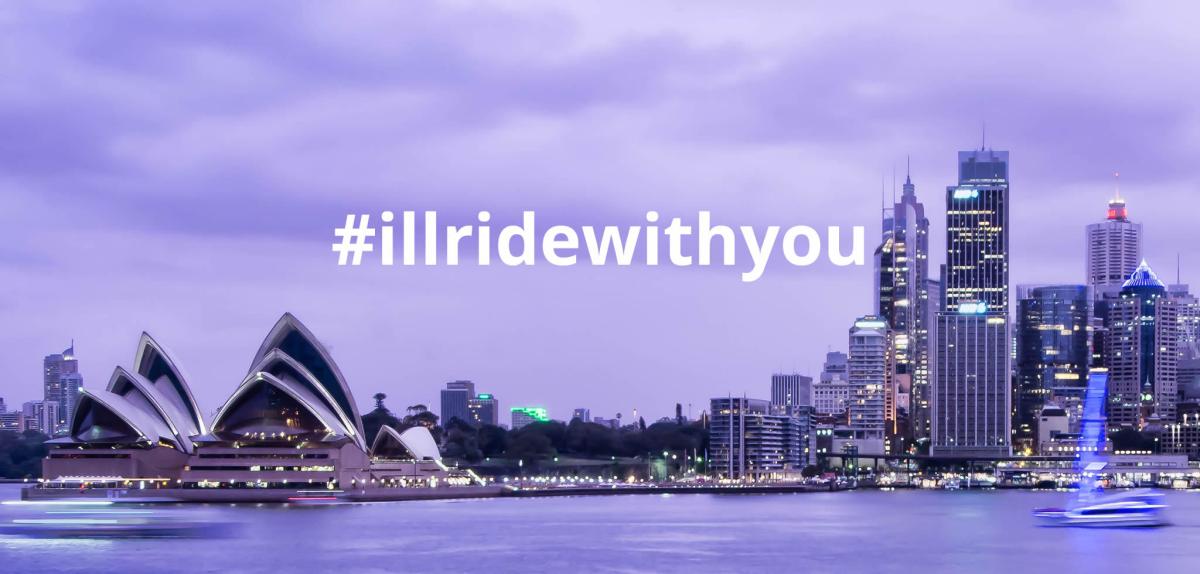 Sydney Harbor at dusk with Opera House, city skyline, and #illridewithyou text overlay