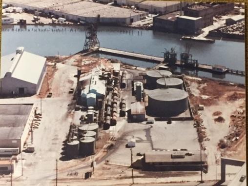Aerial view of industrial facility with storage tanks and equipment adjacent to Islais Creek waterway.