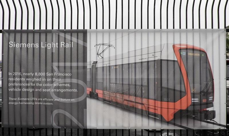 Siemens Light Rail vehicle with red and black exterior design on display banner.