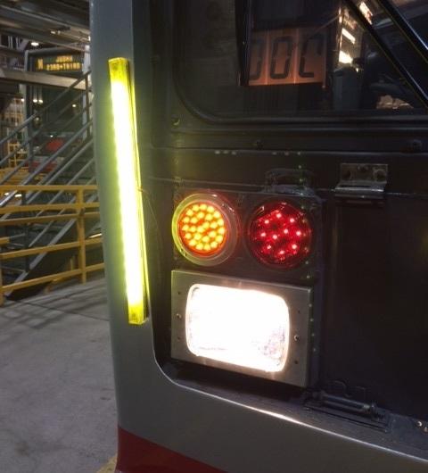 LED flashing lights mounted on back of transit vehicle with yellow warning light and red signal lights.