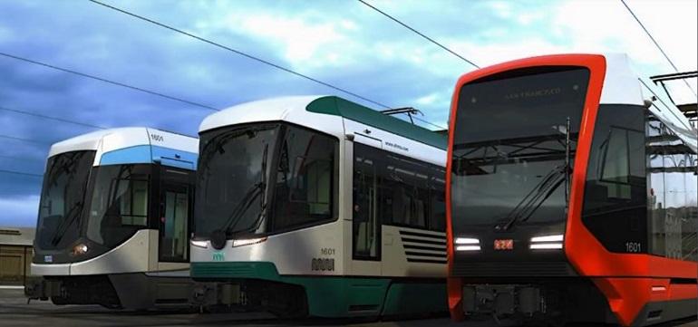 Three modern light rail vehicles in a train yard, featuring white/green and red designs with updated styling.