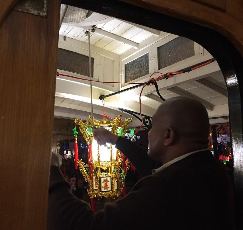 Man operating cable car bell during Chinese New Year Parade on Market Street