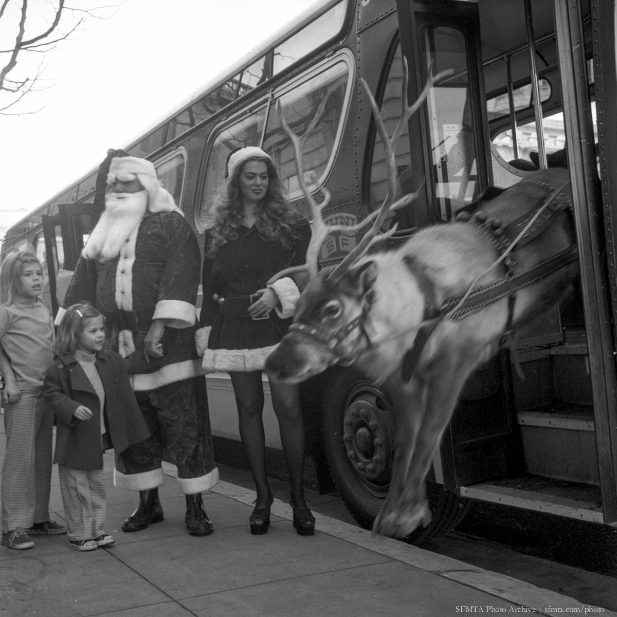 Santa Claus and reindeer exiting a Muni bus while children watch, December 1973