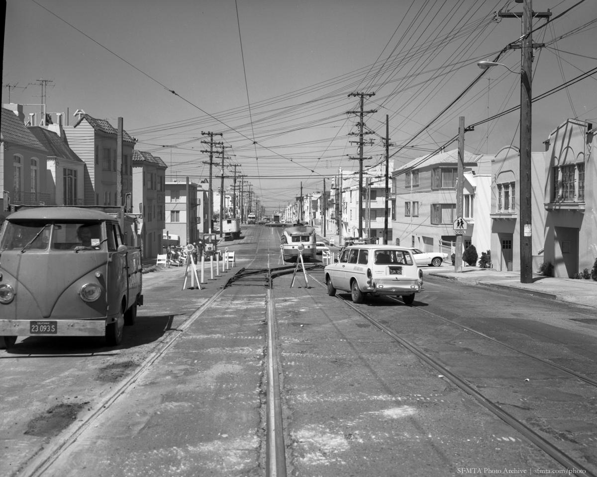 Judah Street with temporary streetcar crossover track, cars, and utility poles, 1974
