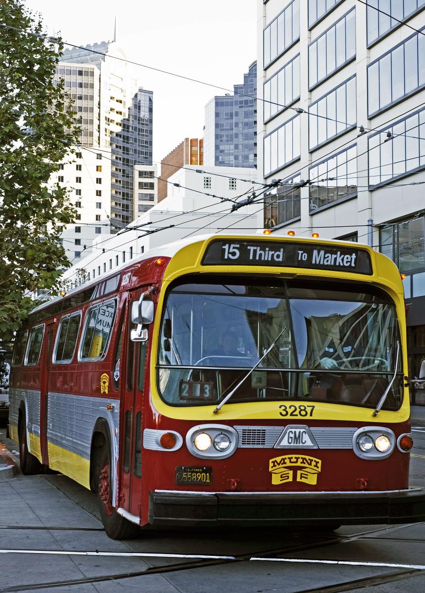 Red and yellow Muni bus number 3287 on tracks heading to Third and Market in San Francisco downtown.