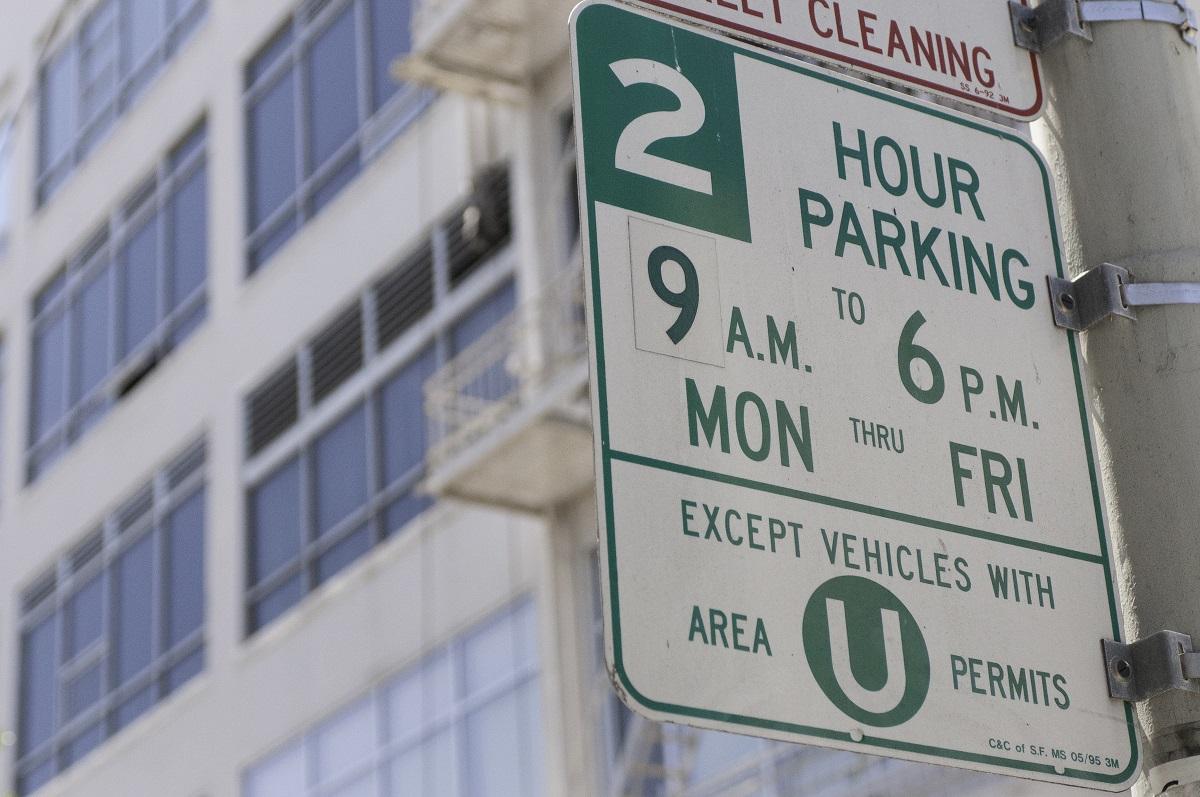 Street parking sign showing 2-hour limit 9am-6pm weekdays, except for Area U permit holders