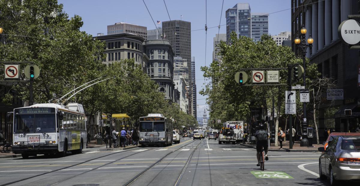Buses, cars and bicycles traveling on Market Street in downtown San Francisco