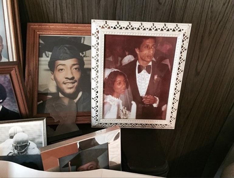 Family photographs displayed on a piano, including a wedding photo in a decorative white frame.